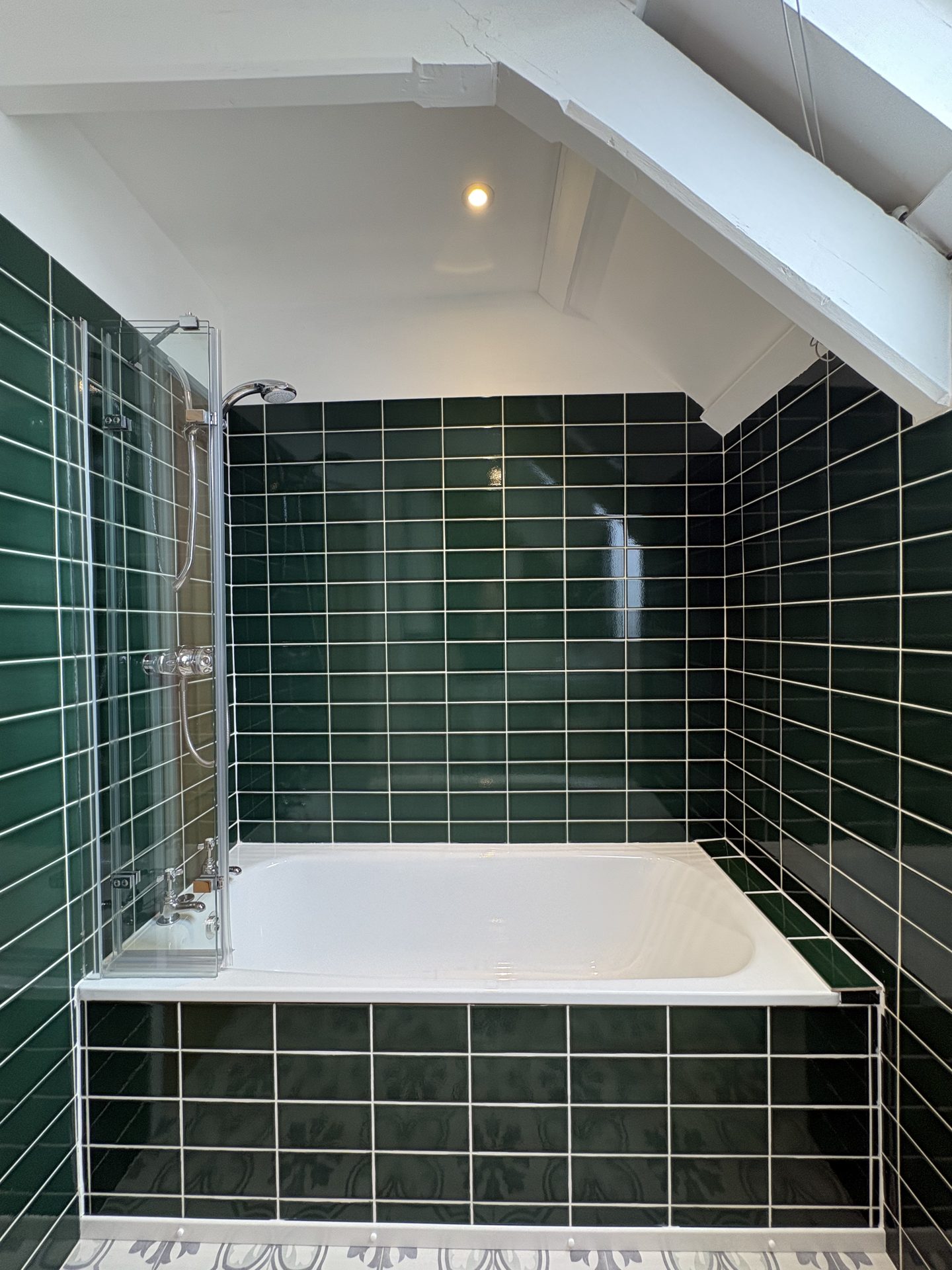 Family bathroom with green tiled bath and shower