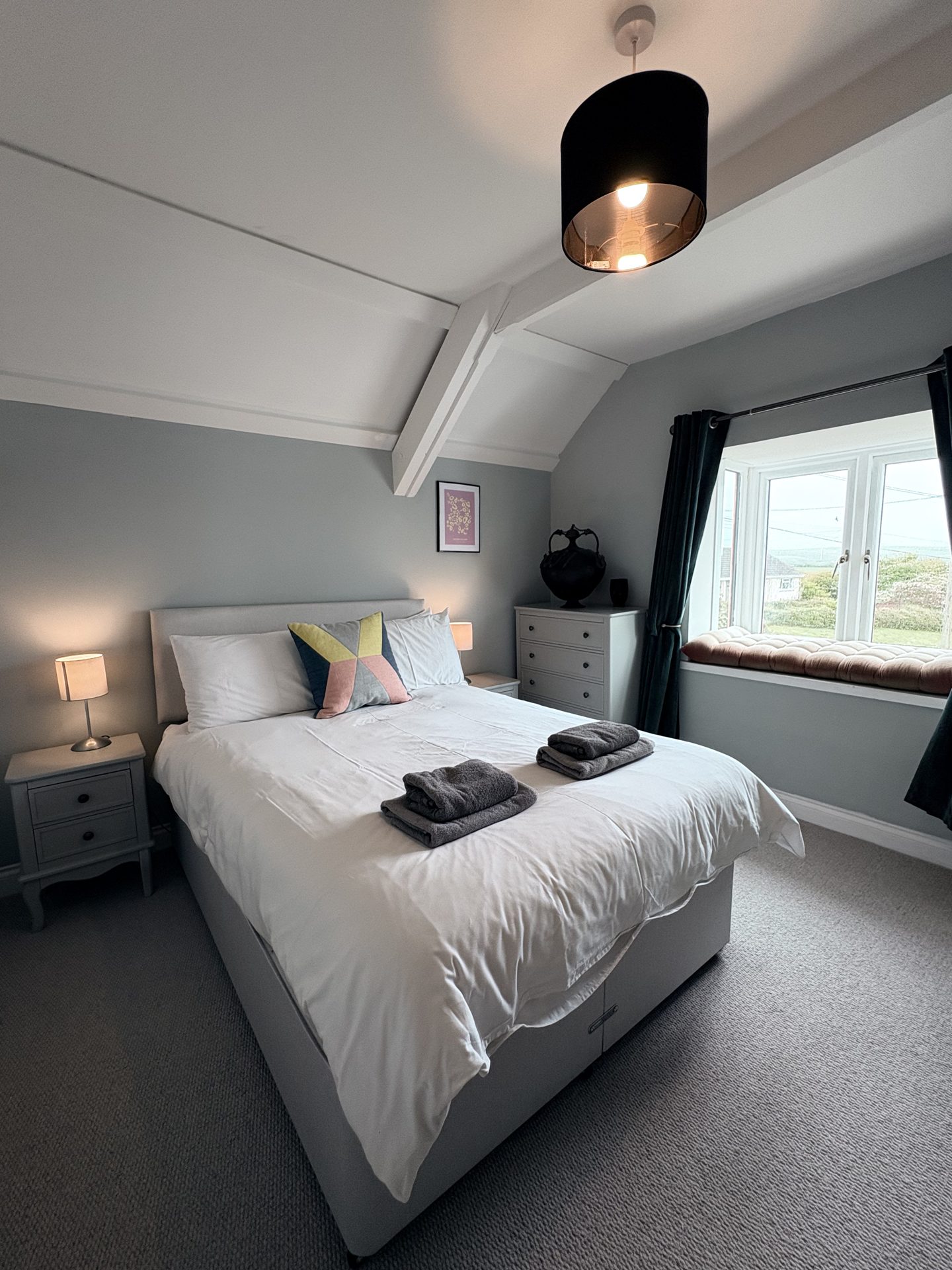 Second bedroom with double bed and colourful cushions
