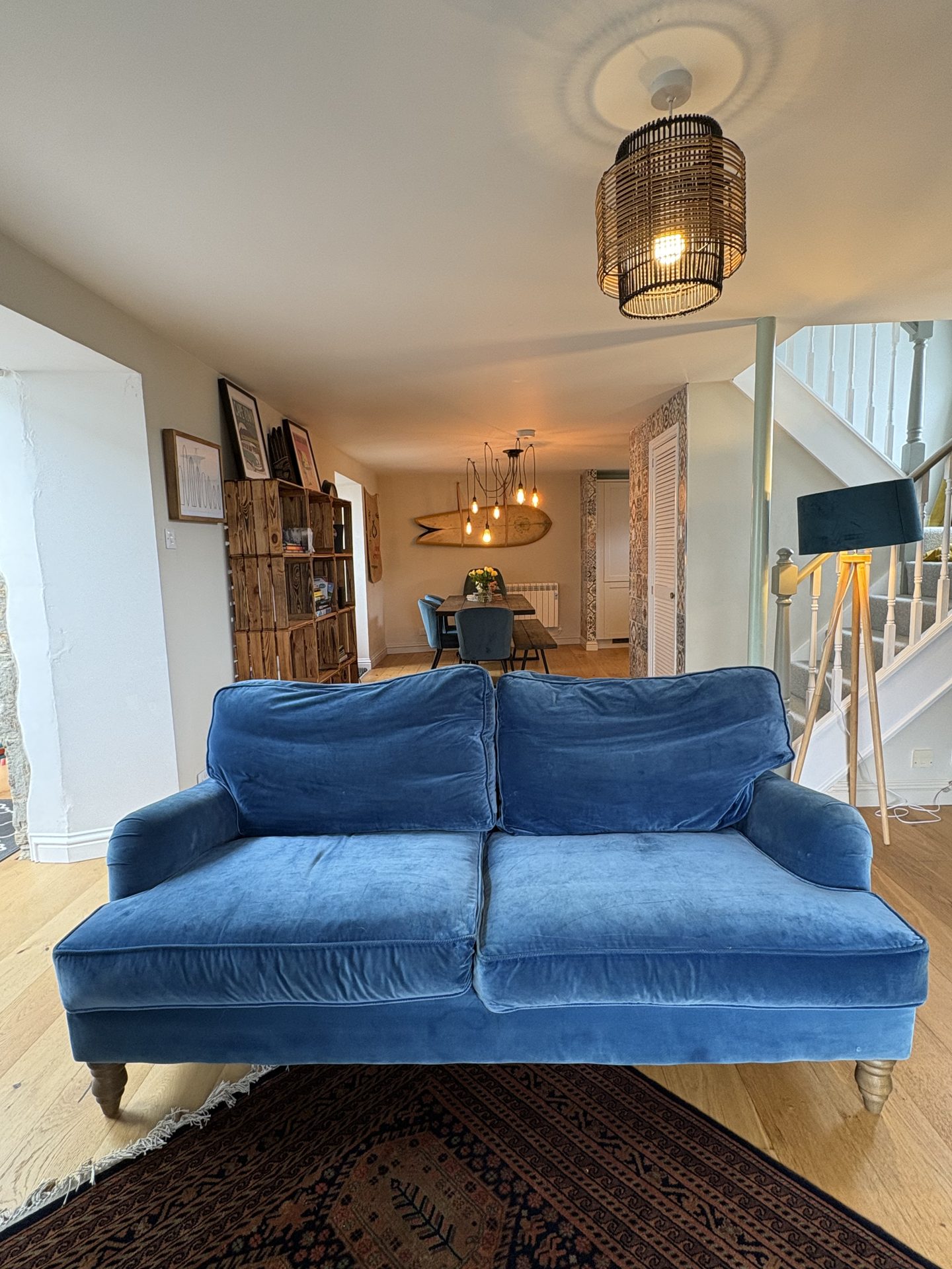 Open-plan living and dining space with blue velvet sofa